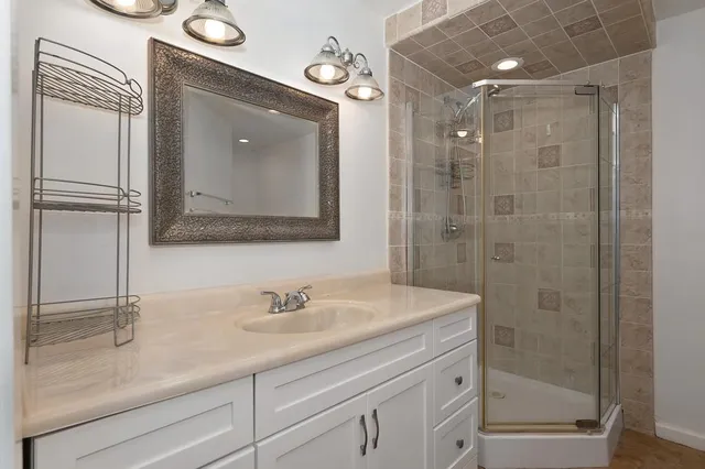 a bathroom with a shower sink and mirror