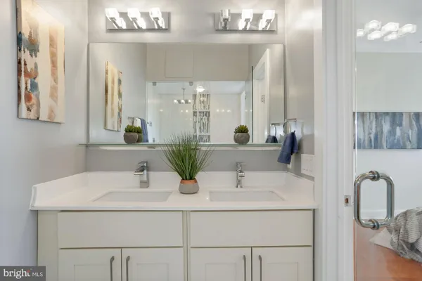 a bathroom with double vanity sinks and a mirror