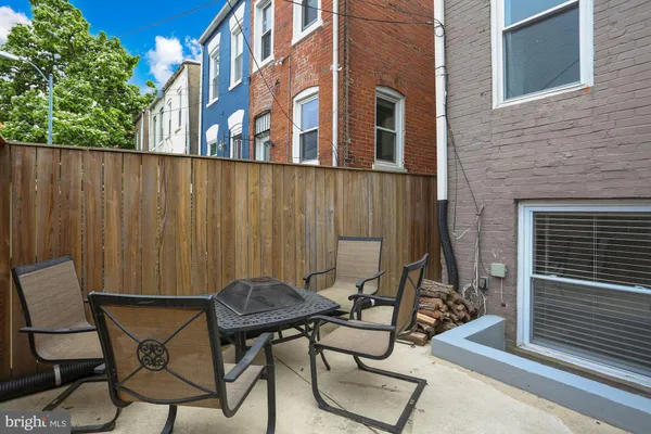 a view of a chairs and table in the back yard of the house
