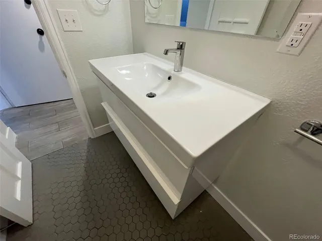 a spacious bathroom with a toilet sink and mirror