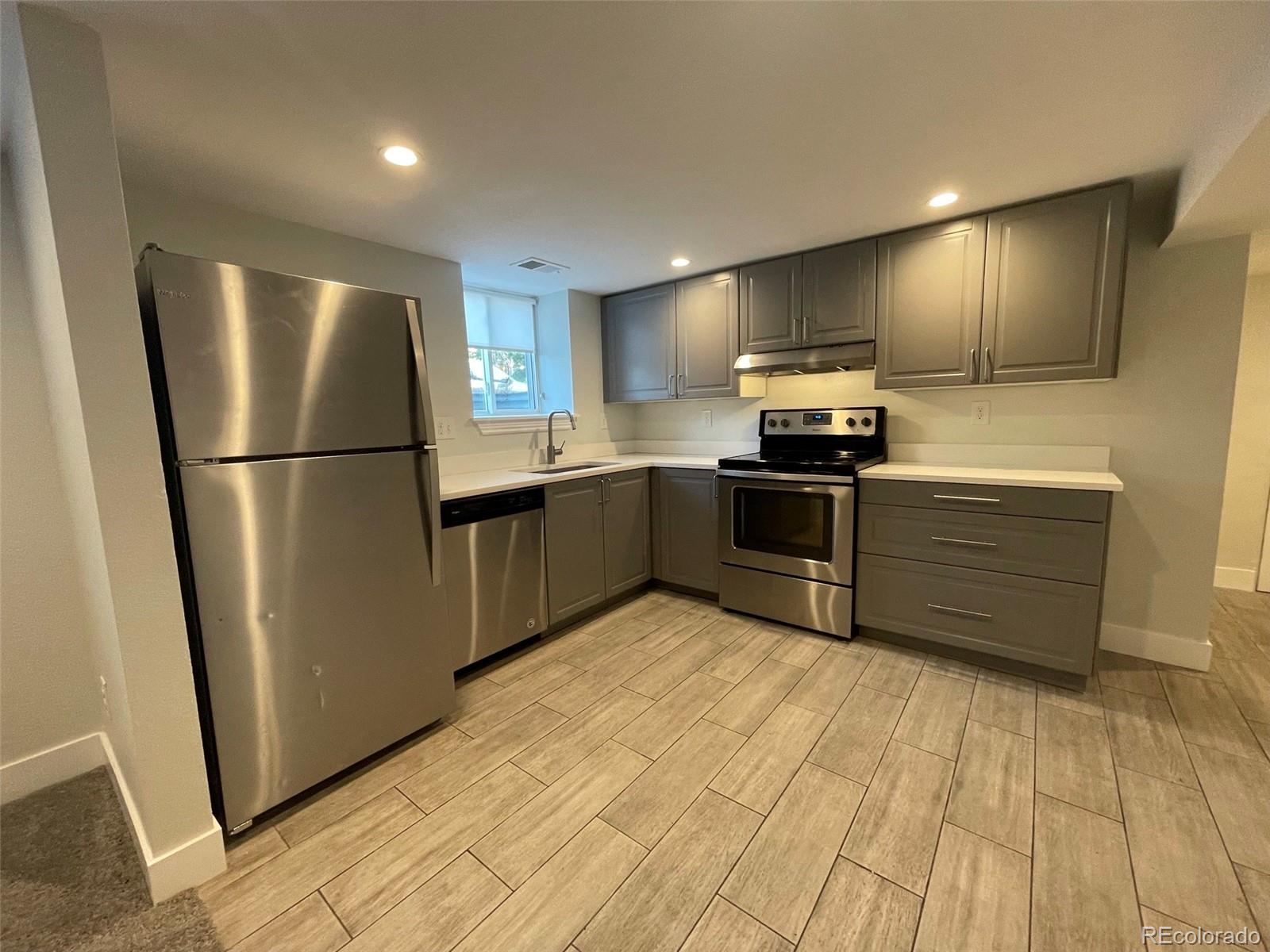 1691 Monroe Street Denver, CO 80206 - Photo 3 of 31 a kitchen with stainless steel appliances granite countertop a refrigerator a sink a stove and oven