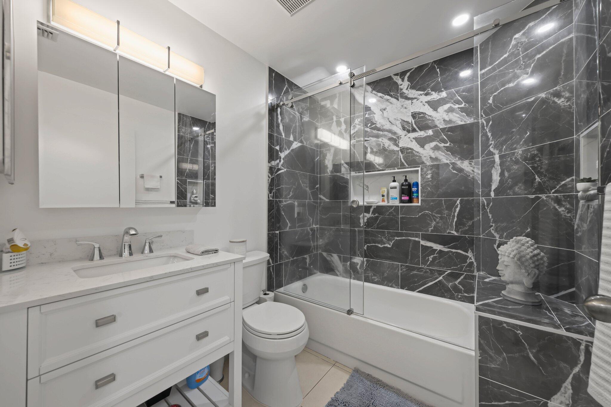 10678 Santa Laguna Drive Boca Raton, FL 33428 - Photo 21 of 40 a bathroom with a bathtub shower sink vanity and toilet