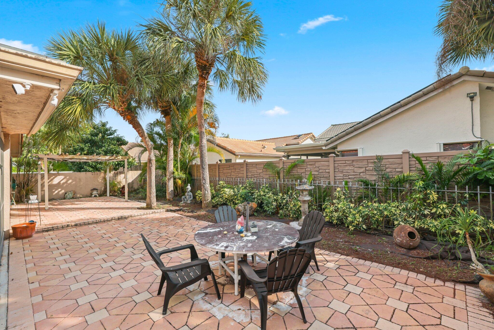 10678 Santa Laguna Drive Boca Raton, FL 33428 - Photo 24 of 40 a view of a patio with table and chairs and potted plants