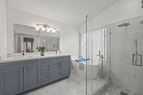 a spacious bathroom with a shower a mirror and a sink