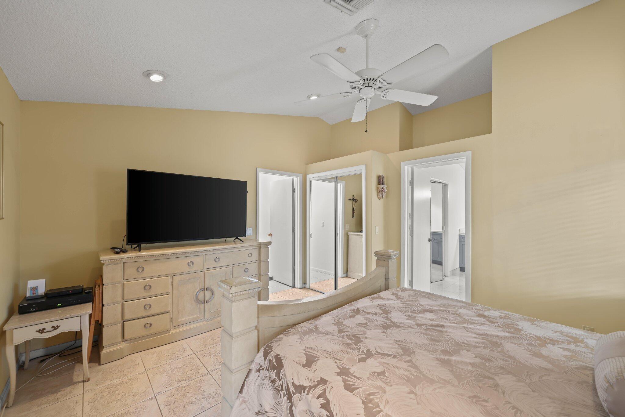 10678 Santa Laguna Drive Boca Raton, FL 33428 - Photo 6 of 40 a bedroom with a bed and a flat screen tv