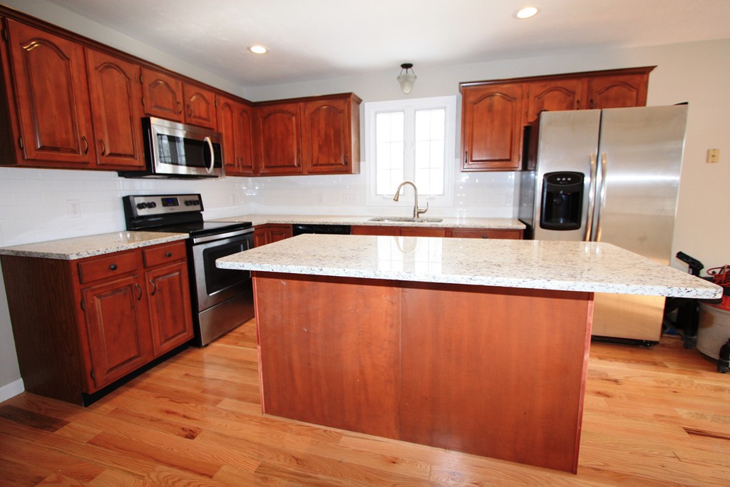 14 Cedar Hill Road Sutton, MA 01590 - Photo 9 of 16 a kitchen with stainless steel appliances granite countertop a sink stove microwave and refrigerator