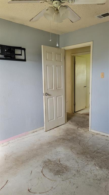 902 South Old Temple Road Hewitt, TX 76643 - Photo 10 of 32 Room featuring a ceiling fan with integrated lighting, textured ceiling, light blue walls, and a panel door