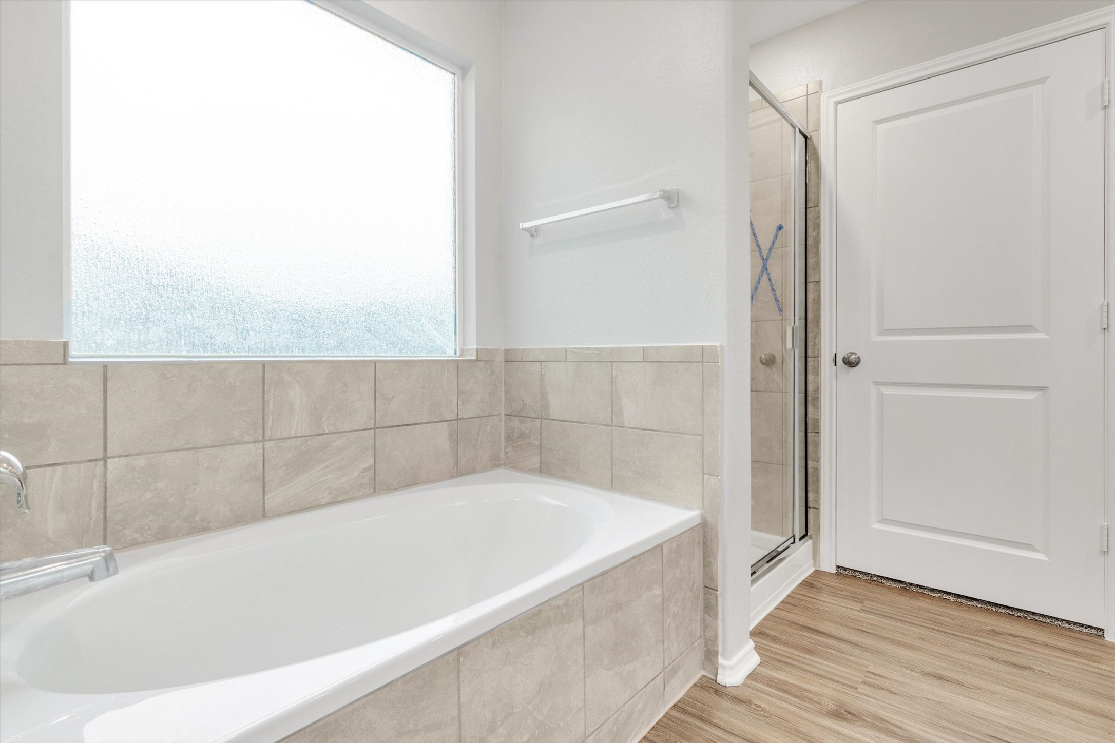 301 Blue Springs Pass Kyle, TX 78640 - Photo 12 of 20 Bathroom featuring a garden tub, a stall shower, and light wood-style floors