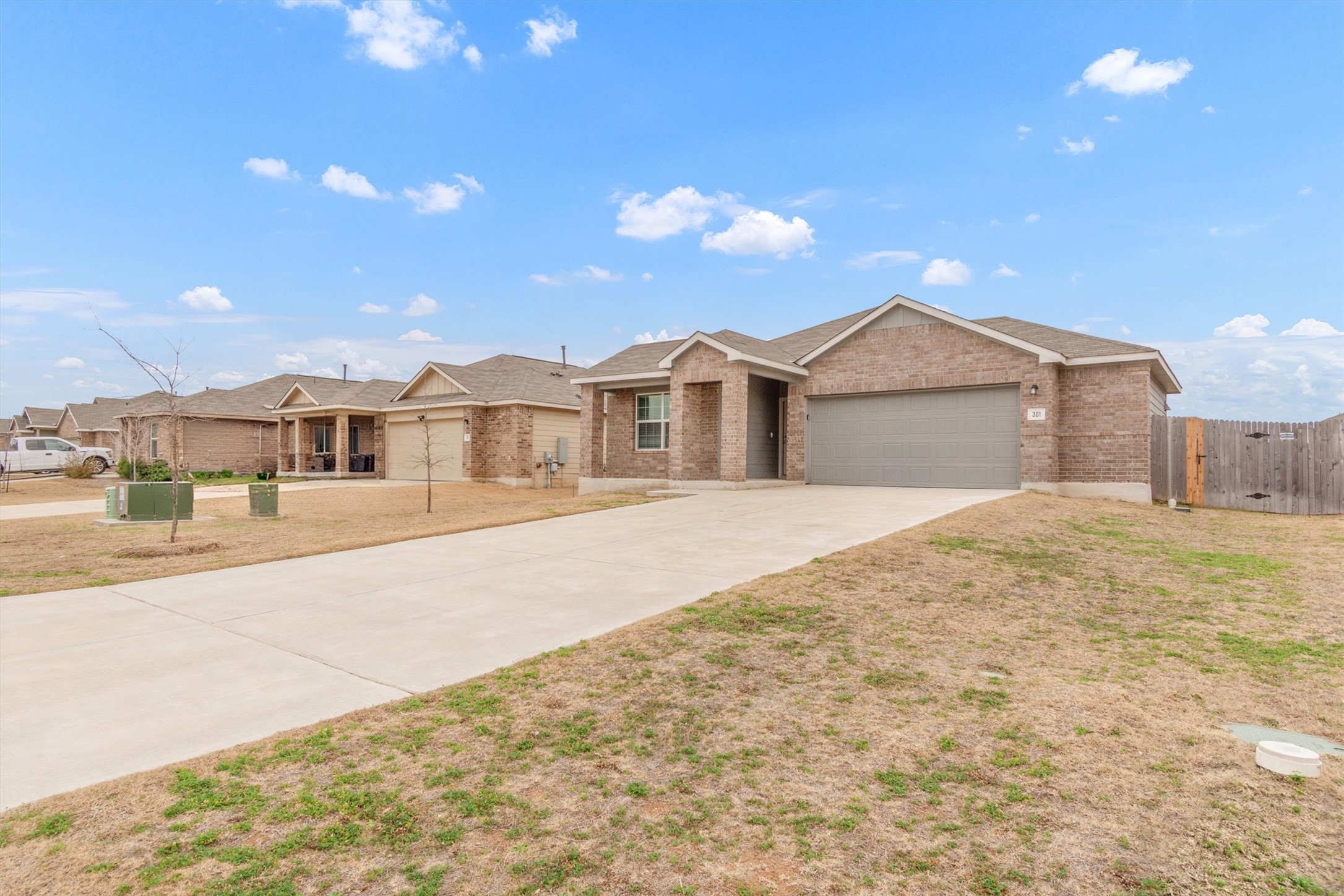 301 Blue Springs Pass Kyle, TX 78640 - Photo 2 of 20 Ranch-style home featuring a gate, concrete driveway, brick siding, and an attached garage