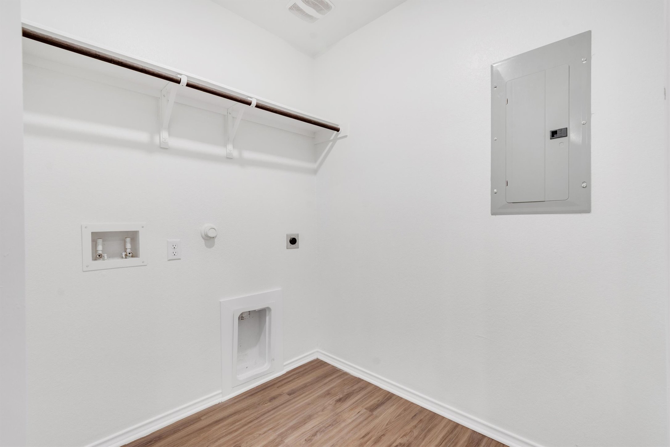 301 Blue Springs Pass Kyle, TX 78640 - Photo 7 of 20 Laundry area featuring gas dryer hookup, electric panel, light wood-style flooring, hookup for an electric dryer, and washer hookup
