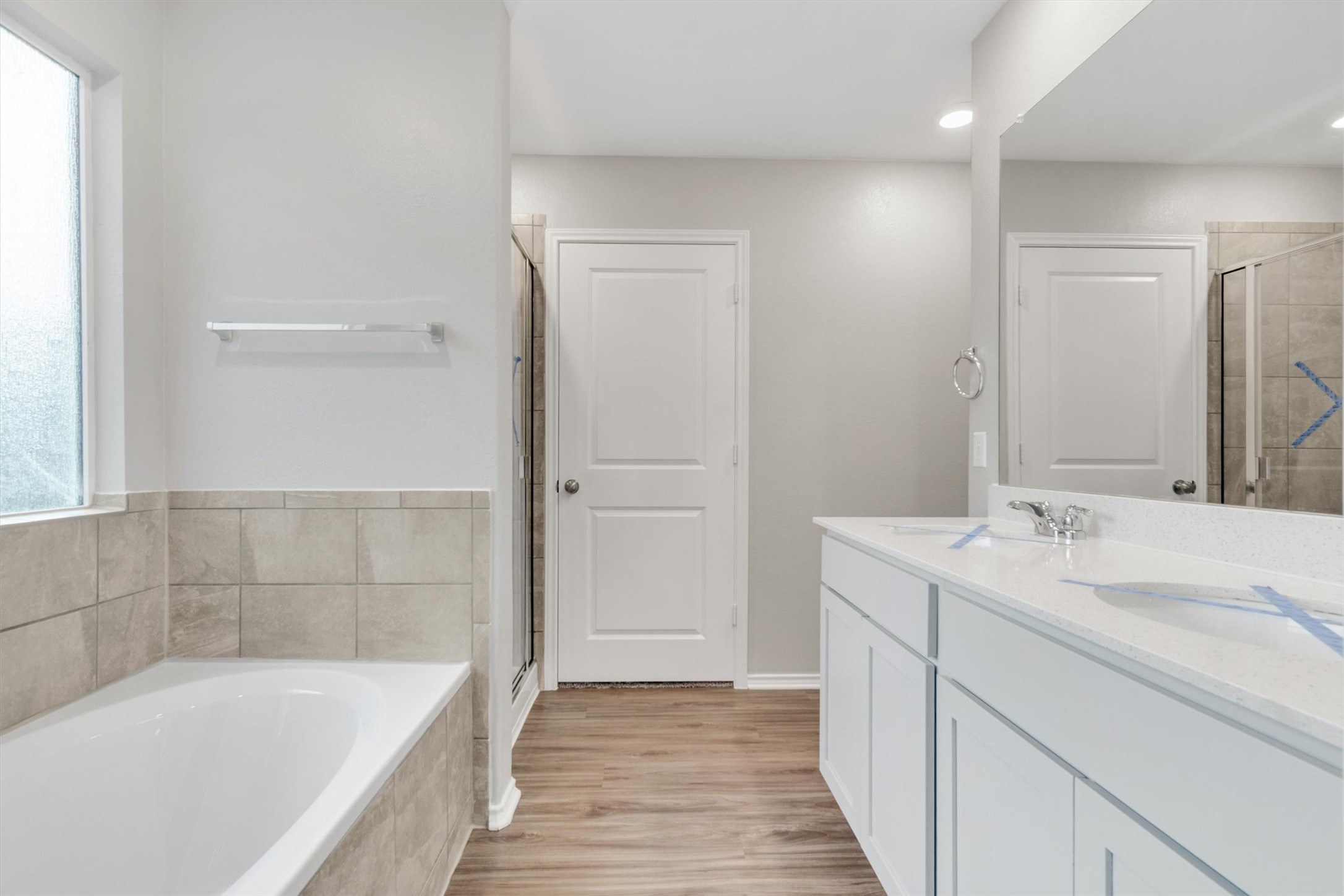 301 Blue Springs Pass Kyle, TX 78640 - Photo 9 of 20 Full bath with a shower stall, double vanity, a garden tub, and light wood finished floors