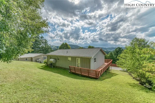 a view of a house with a yard and potted plants