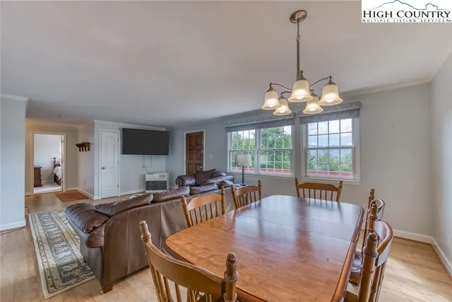 a view of a dining room with furniture wooden floor and chandelier