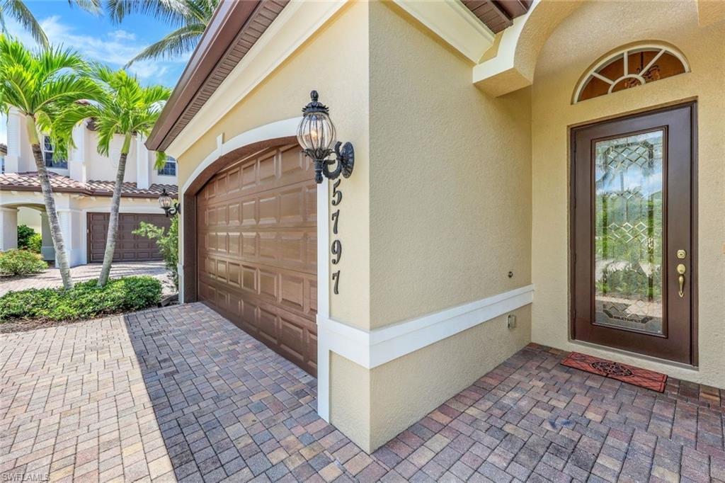 5797 Mango Circle, Unit 5797 Naples, FL 34110 - Photo 1 of 22 a front view of a house with garden