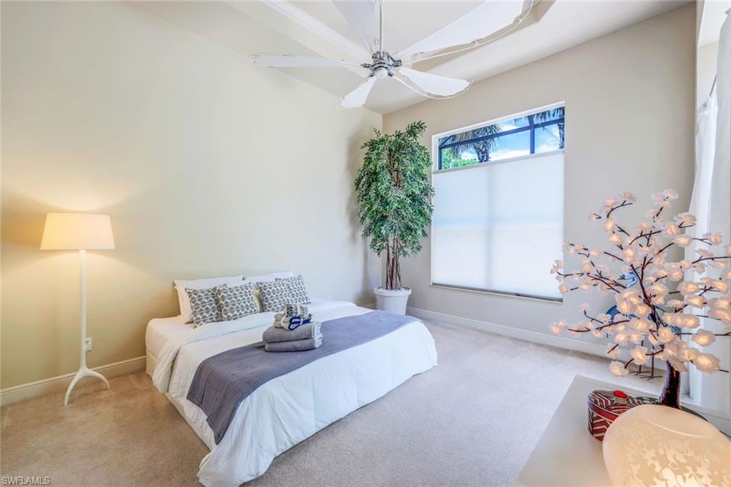 5797 Mango Circle, Unit 5797 Naples, FL 34110 - Photo 13 of 22 a bedroom with a large bed and a potted plant