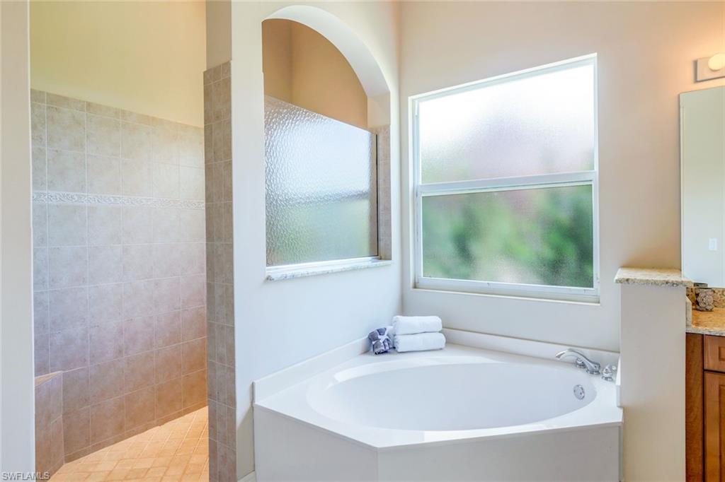 5797 Mango Circle, Unit 5797 Naples, FL 34110 - Photo 16 of 22 a white bath tub sitting next to a window
