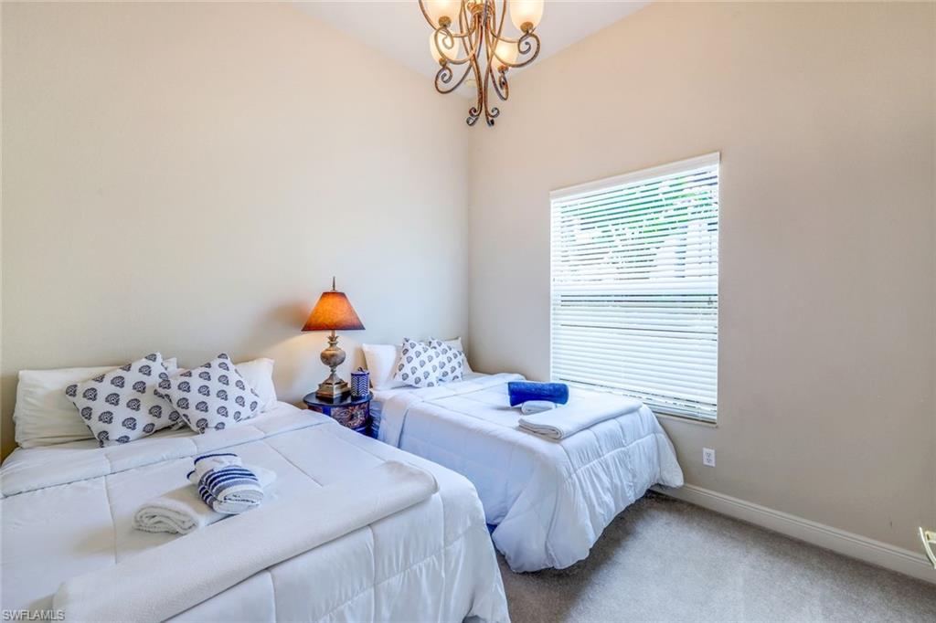 5797 Mango Circle, Unit 5797 Naples, FL 34110 - Photo 18 of 22 a bedroom with two beds and window