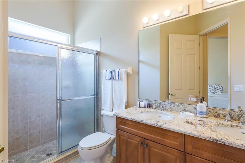 5797 Mango Circle, Unit 5797 Naples, FL 34110 - Photo 19 of 22 a bathroom with a granite countertop sink toilet and shower