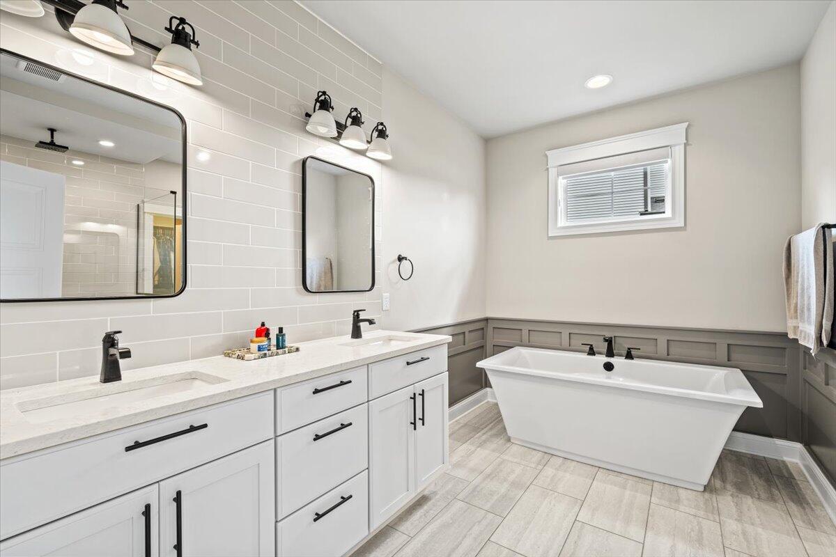 12893 Baker Court Crown Point, IN 46307 - Photo 20 of 52 a spacious bathroom with a double vanity sink mirror and bathtub