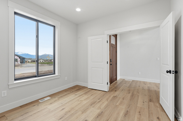 2970 North Mahogany Vly Road Logan, UT 84341 - Photo 16 of 39 Spare room featuring light wood-type flooring, a mountain view, and recessed lighting