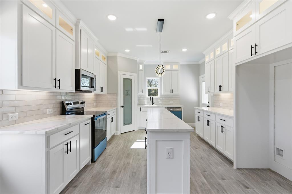 420 Ball Street Tom Bean, TX 75491 - Photo 9 of 34 a kitchen with white cabinets and stainless steel appliances