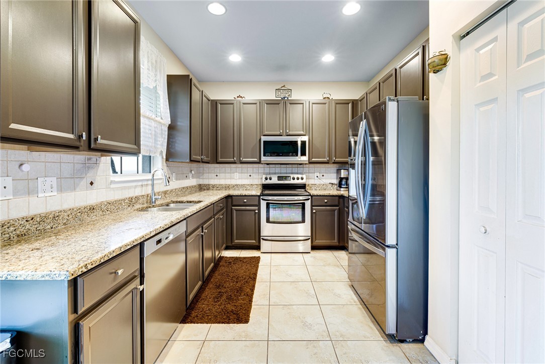 8657 Sumner Avenue Fort Myers, FL 33908 - Photo 6 of 29 a kitchen with stainless steel appliances granite countertop a sink stove and refrigerator