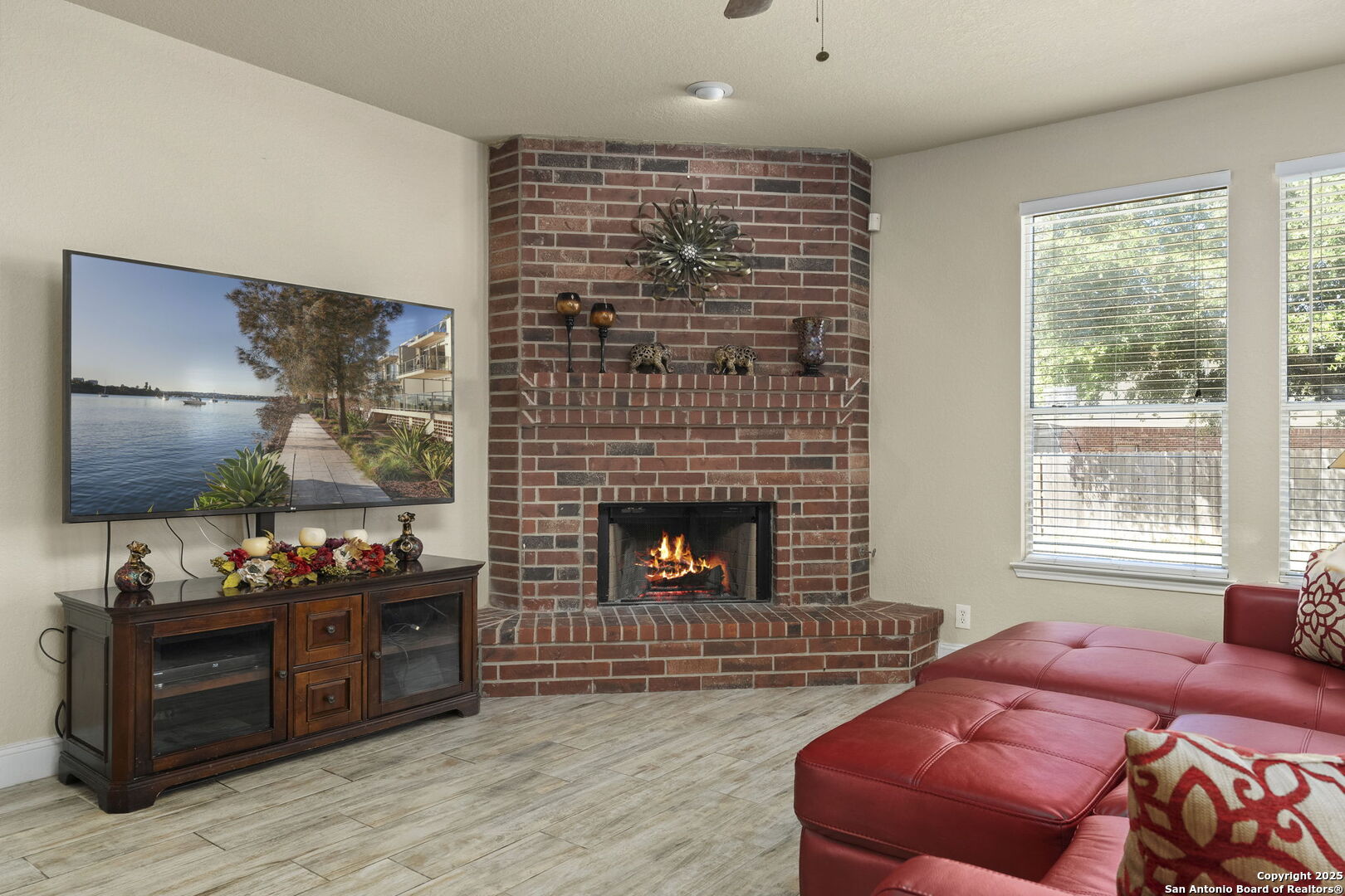 8747 Feather Trail Helotes, TX 78023 - Photo 15 of 34 a living room with furniture a flat screen tv and a fireplace