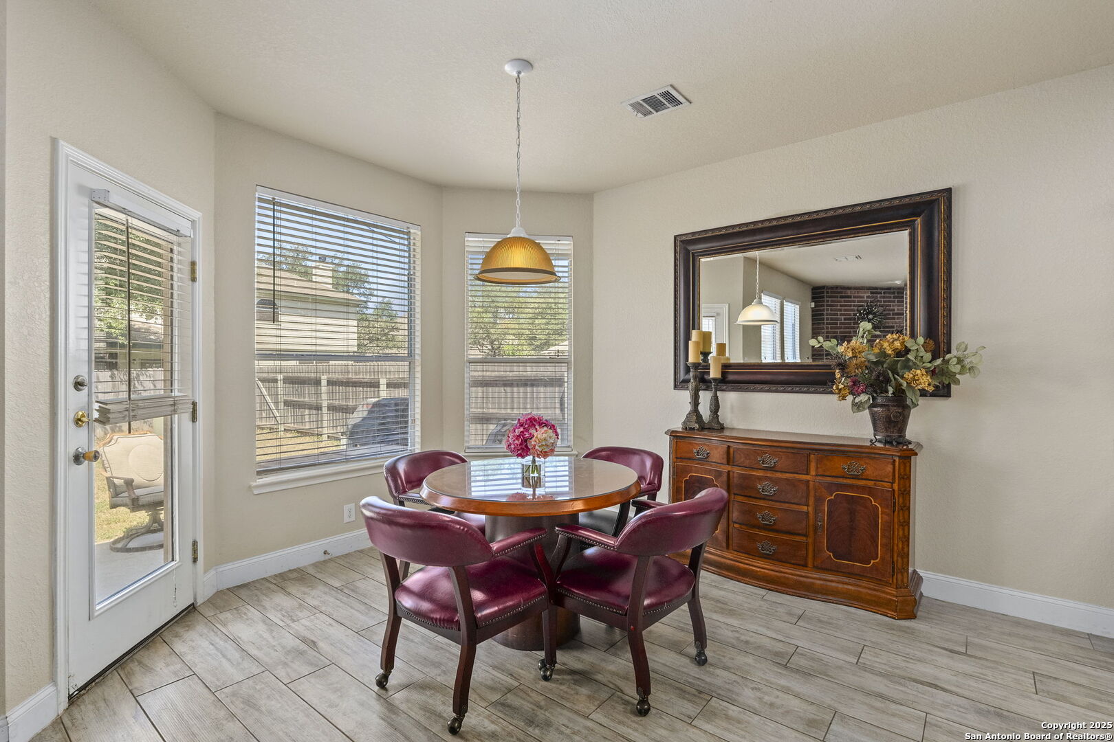 8747 Feather Trail Helotes, TX 78023 - Photo 16 of 34 a dining room with furniture a chandelier and wooden floor