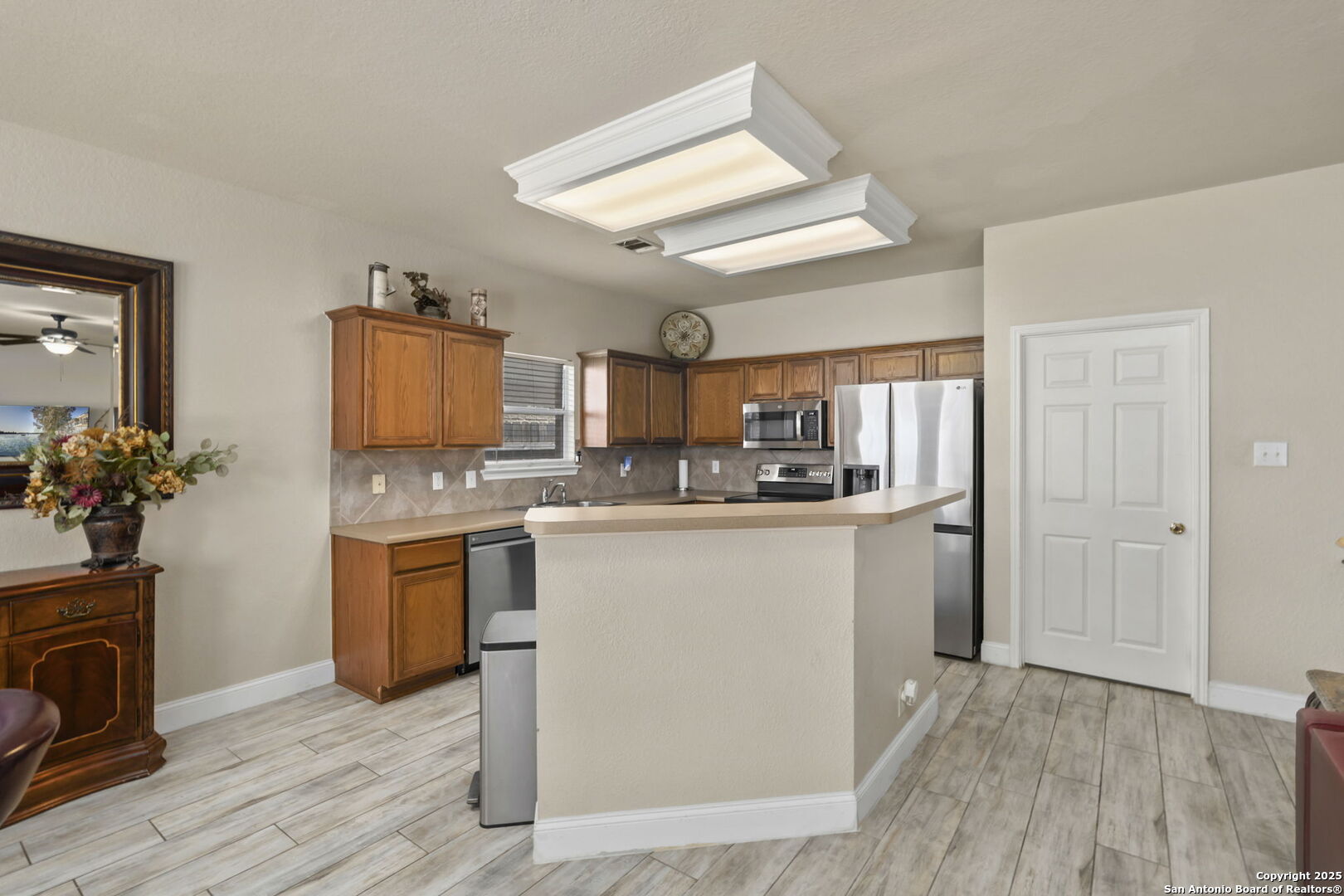 8747 Feather Trail Helotes, TX 78023 - Photo 18 of 34 a kitchen with granite countertop a refrigerator oven a sink dishwasher and white cabinets with wooden floor