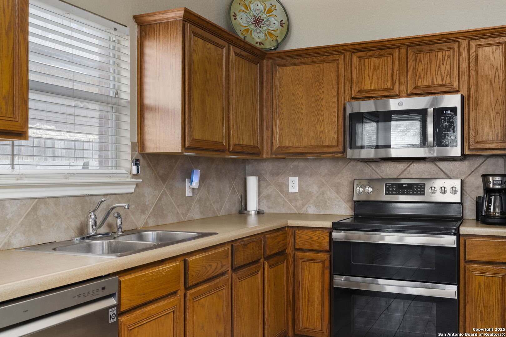 8747 Feather Trail Helotes, TX 78023 - Photo 19 of 34 a kitchen with sink cabinets and stainless steel appliances