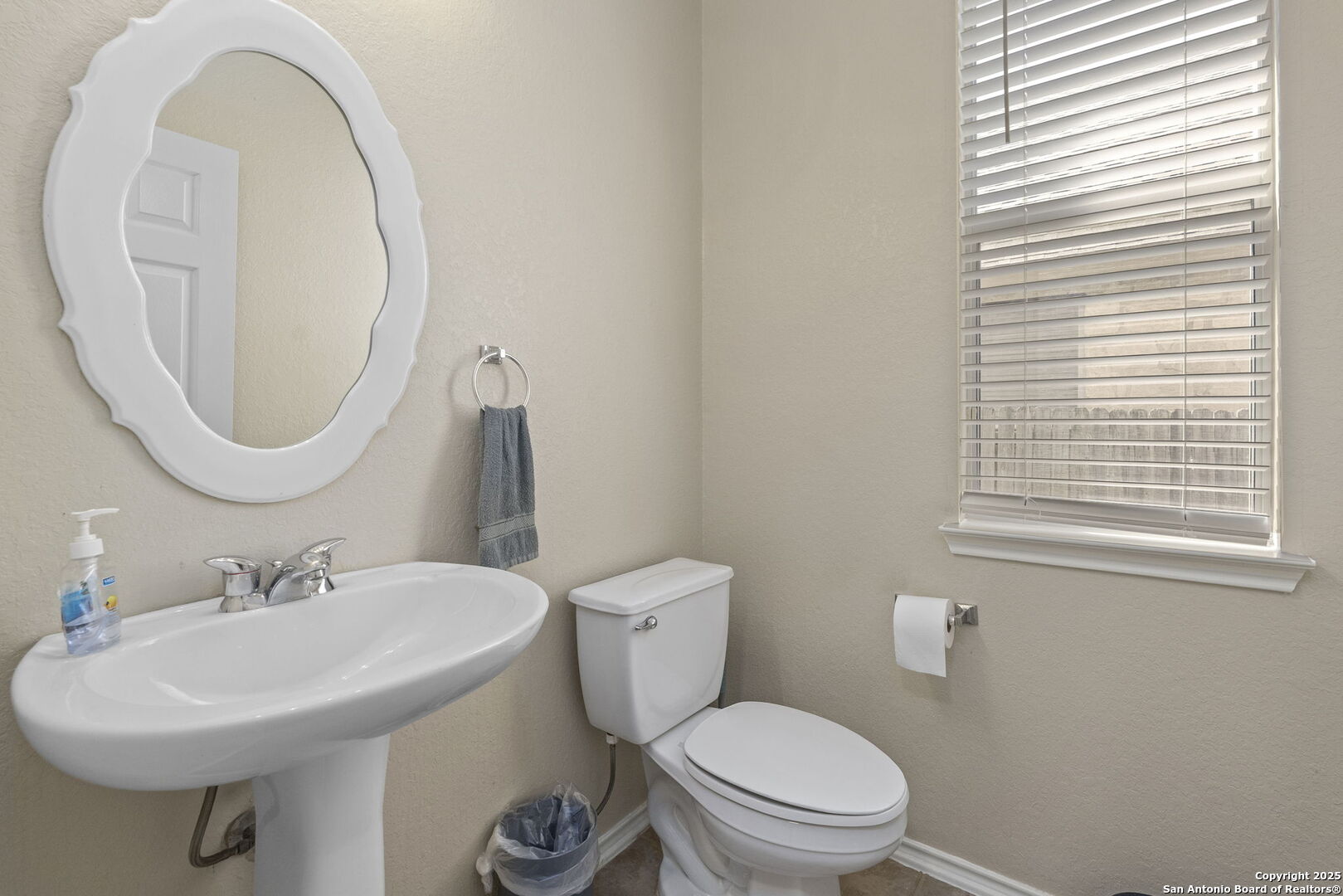 8747 Feather Trail Helotes, TX 78023 - Photo 21 of 34 a bathroom with a toilet a sink and a mirror