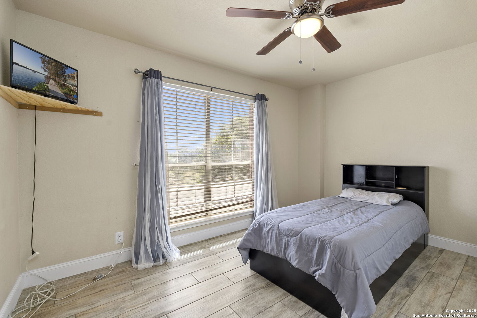 8747 Feather Trail Helotes, TX 78023 - Photo 29 of 34 a bedroom with a bed and a window