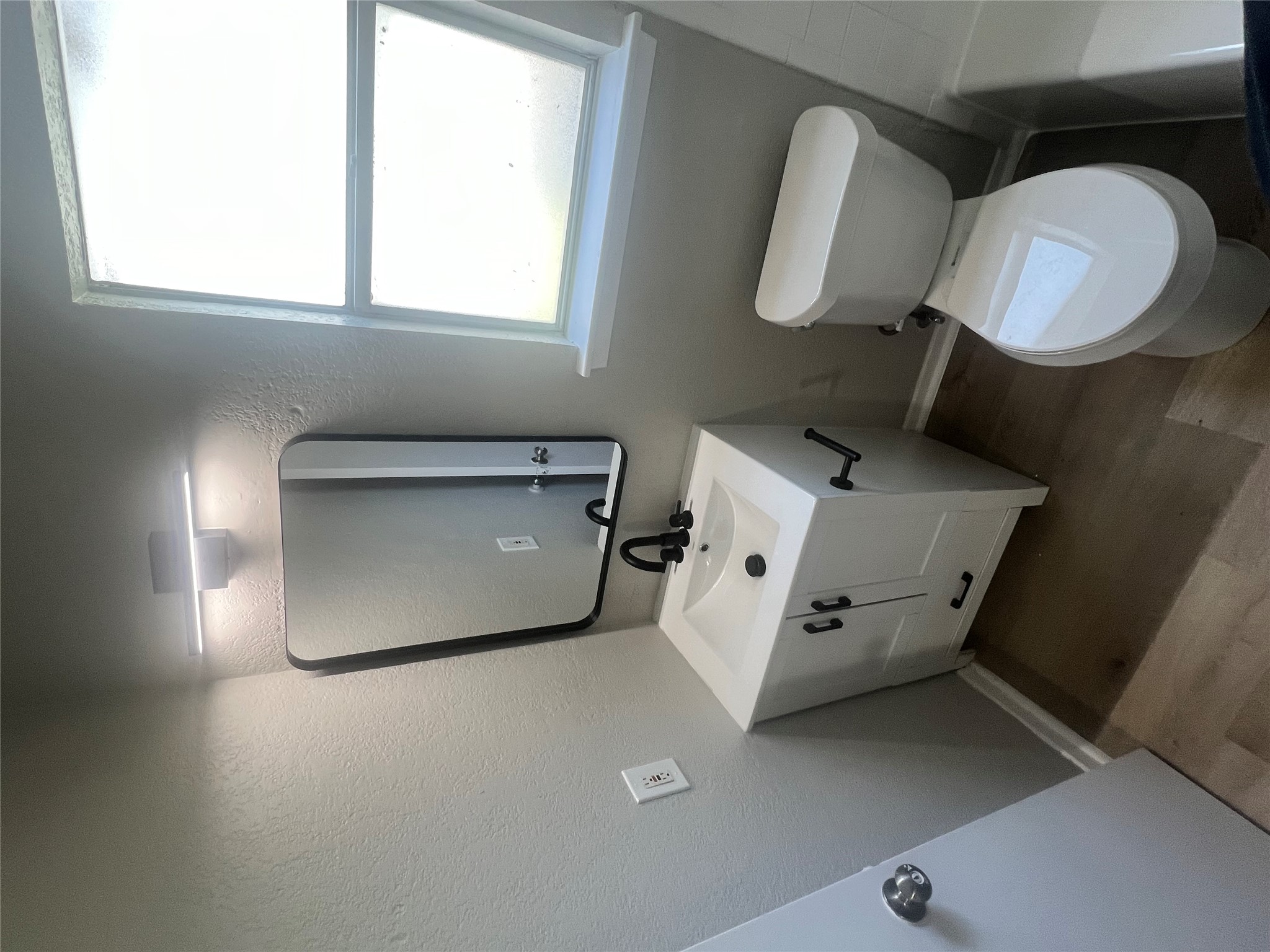 4620 Button Bend Road Austin, TX 78744 - Photo 18 of 22 A well-appointed bathroom features a contemporary vanity and a clear window offering natural illumination.