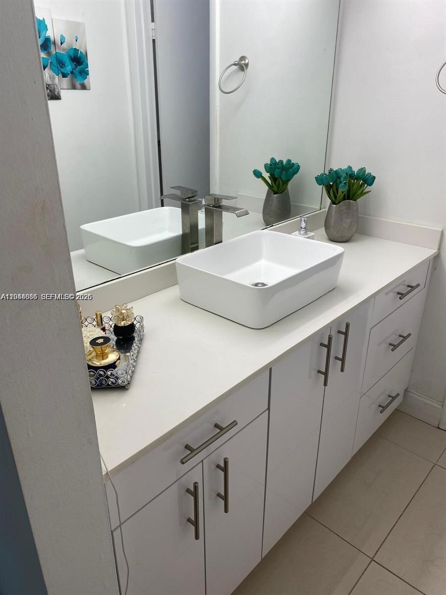 8838 West McNab Road, Unit 104 Tamarac, FL 33321 - Photo 7 of 23 a bathroom with double sink and a mirror