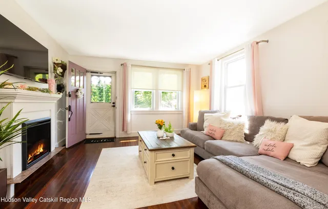 a living room with furniture a fireplace and flat screen tv