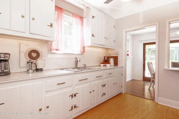 a kitchen with granite countertop white cabinets and white appliances