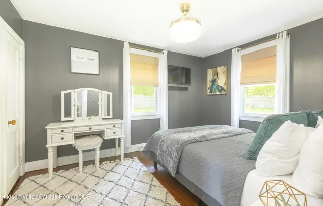 a bed sitting in a bedroom next to a window and chair