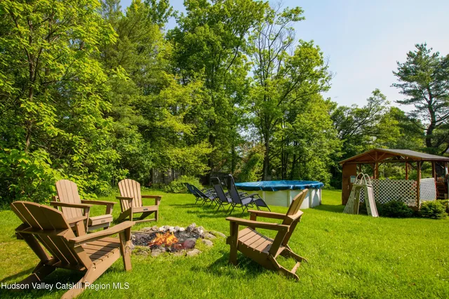 a view of a backyard with chairs and a slide