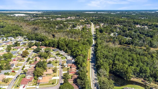 an aerial view of residential house with parking and yard