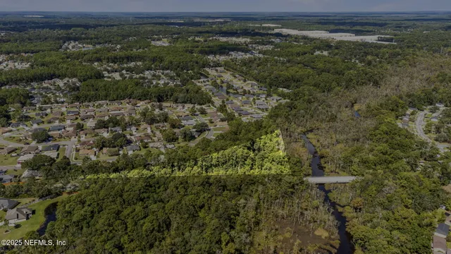 an aerial view of residential house with outdoor space and trees all around