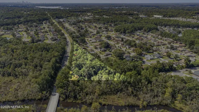 an aerial view of residential house with green space and fog