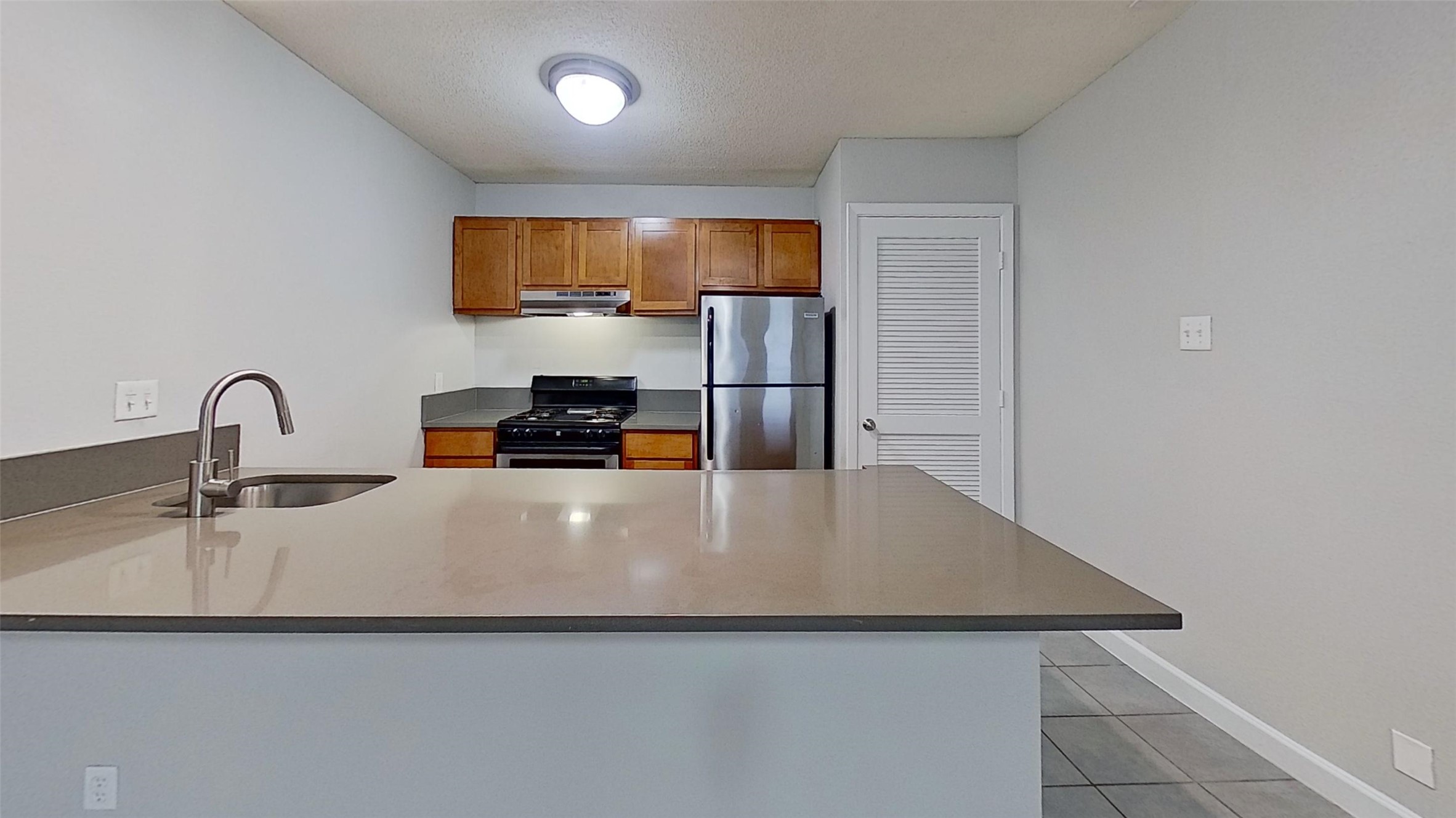 2520 Longview Street, Unit 405 Austin, TX 78705 - Photo 1 of 9 a close view of a sink a counter space and a refrigerator in a room