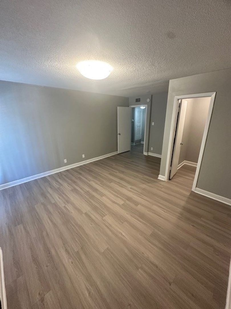 2520 Longview Street, Unit 405 Austin, TX 78705 - Photo 5 of 11 an empty room with wooden floor and mirror