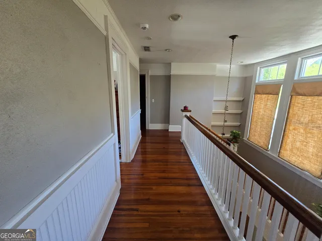 a view of a hallway with wooden floor and staircase