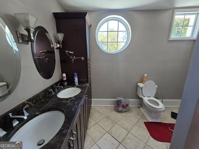 a bathroom with a toilet mirror and vanity