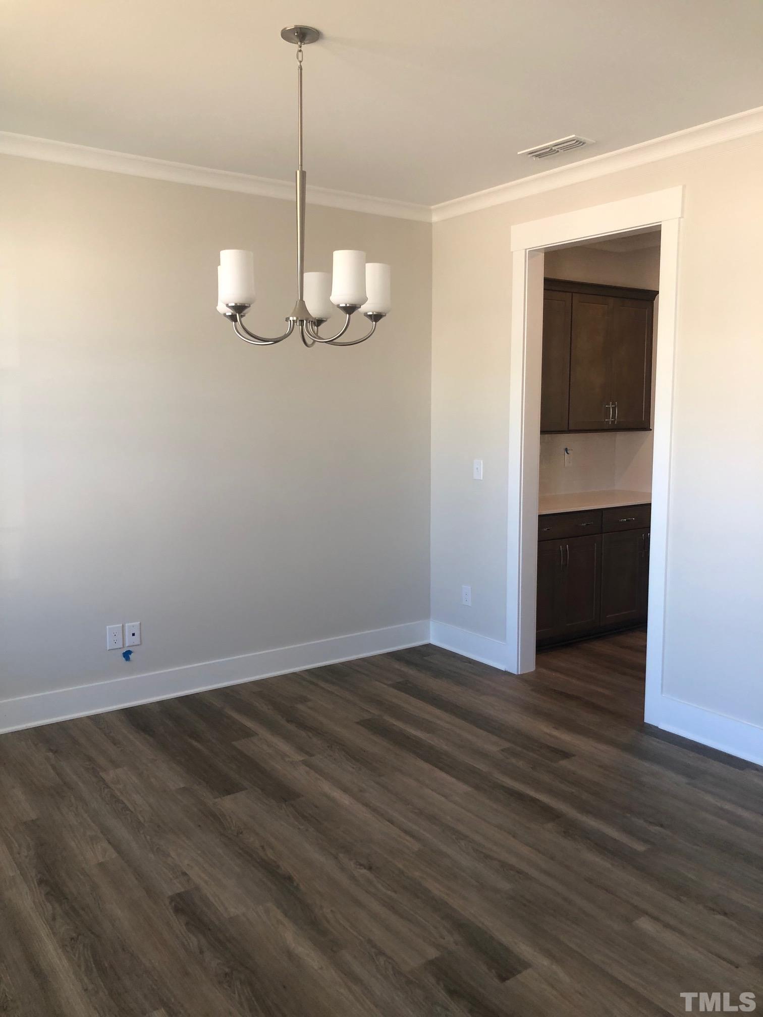 163 DUNLOE Loop Raleigh, NC 27603 - Photo 11 of 32 a view of an empty room with wooden floor and a window