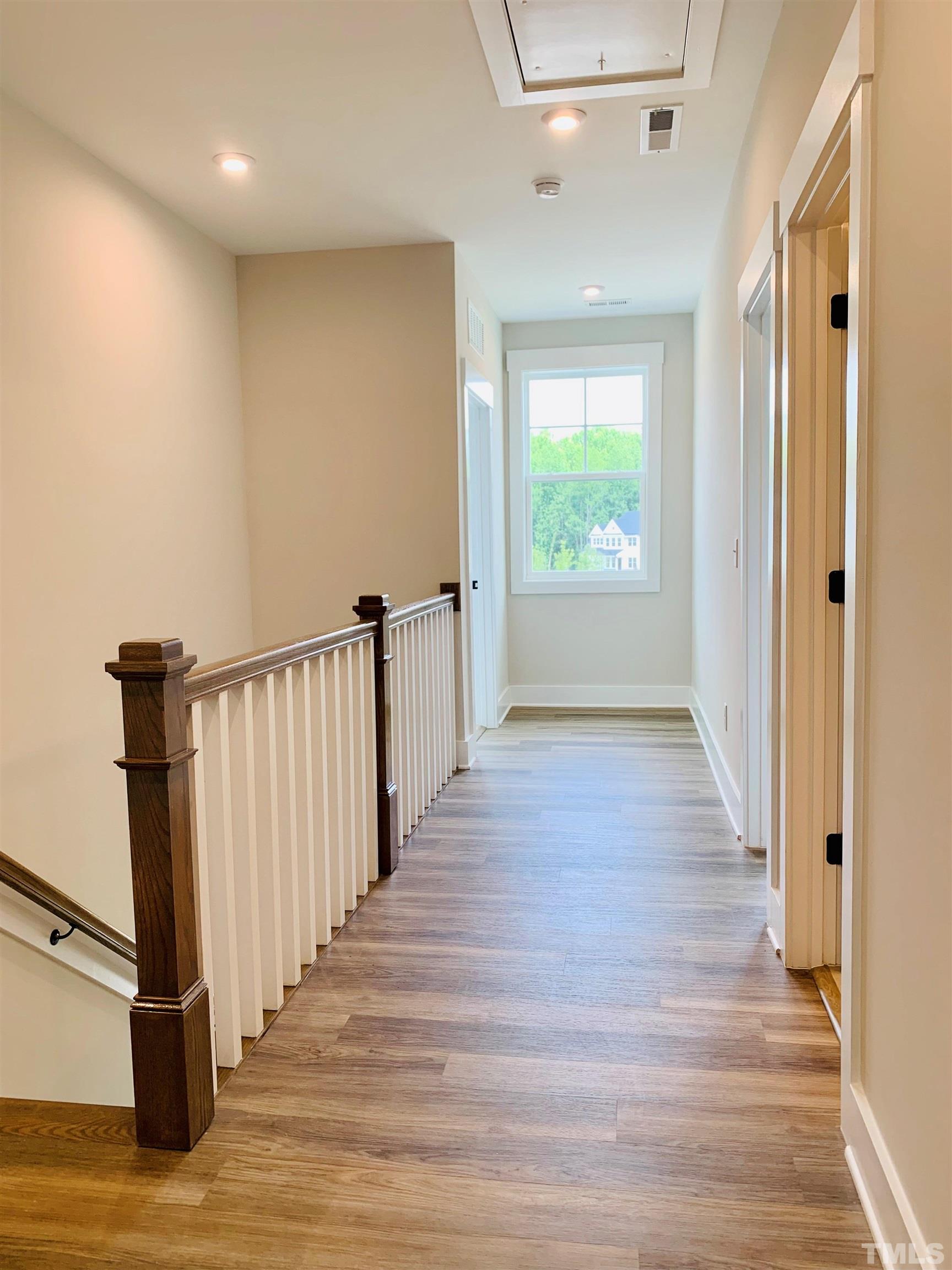163 DUNLOE Loop Raleigh, NC 27603 - Photo 16 of 32 a view of a hallway with wooden floor and staircase