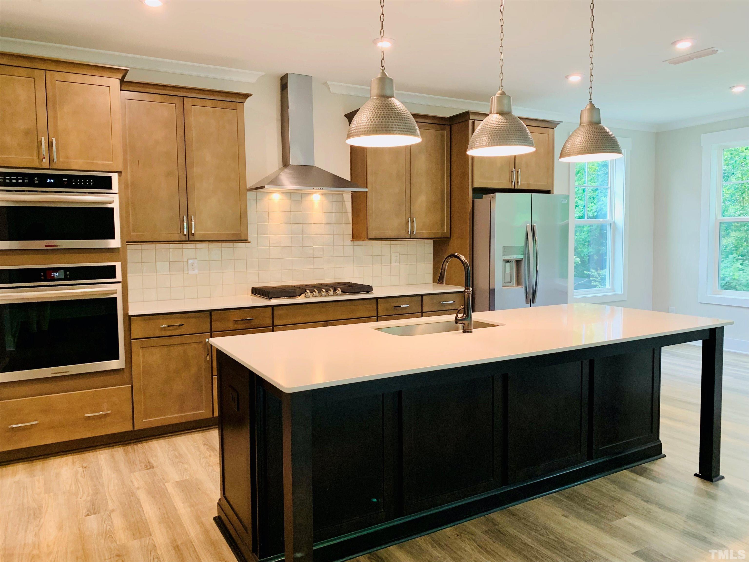 163 DUNLOE Loop Raleigh, NC 27603 - Photo 8 of 32 a kitchen with stainless steel appliances granite countertop a sink a stove and a wooden cabinets