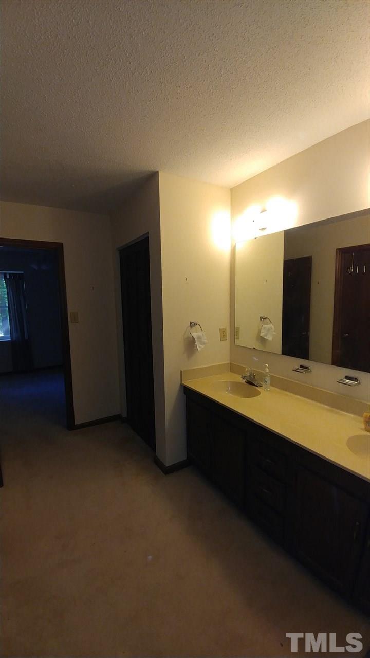 5742 Pool Side Drive Raleigh, NC 27612 - Photo 11 of 13 a bathroom with a double vanity sink and a mirror