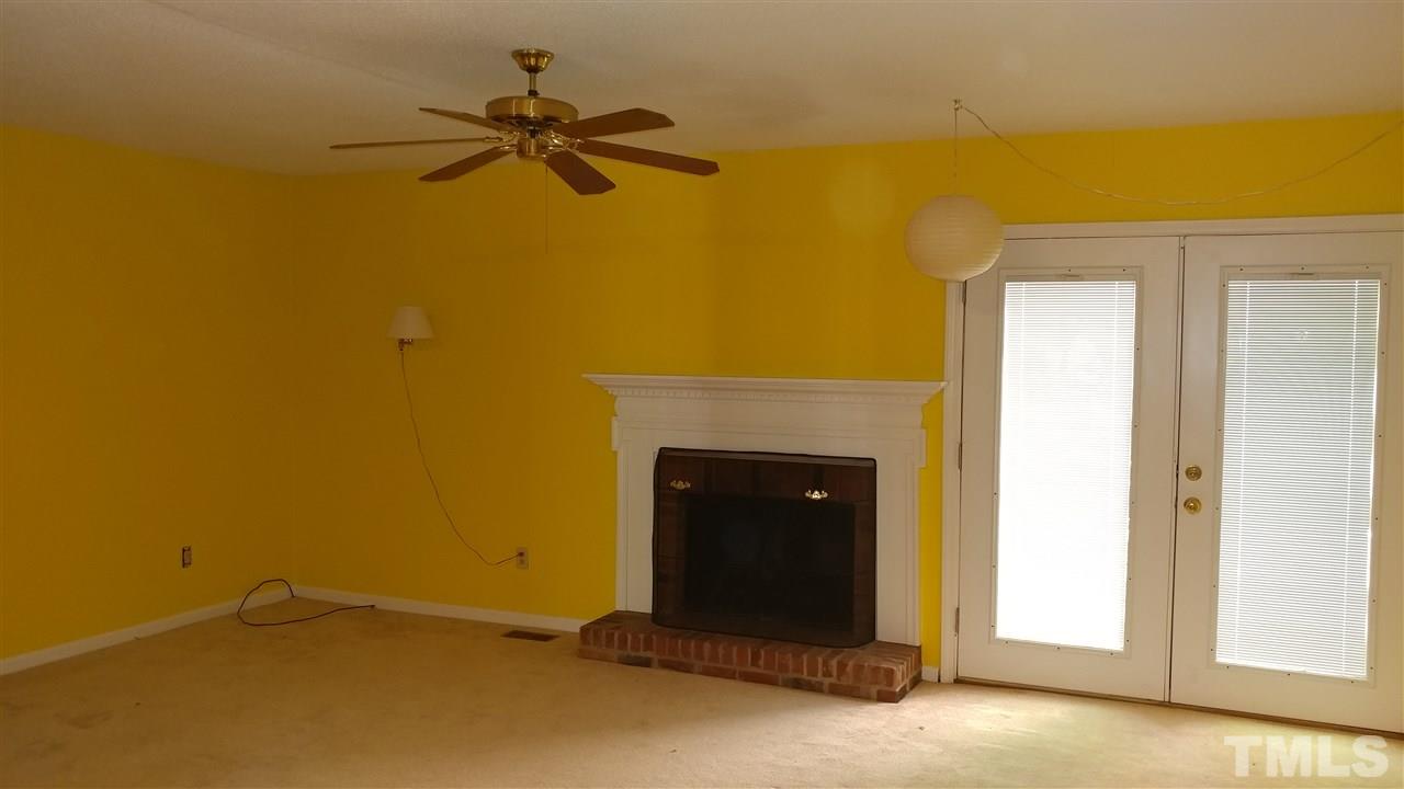 5742 Pool Side Drive Raleigh, NC 27612 - Photo 4 of 13 a view of a livingroom with a fireplace and a ceiling fan